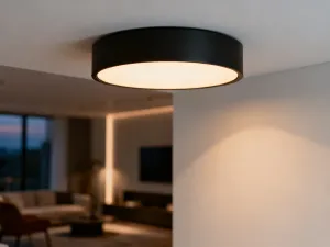 Nowoczesna kuchnia z wyspą i półwyspem, prezentująca eleganckie blaty oraz minimalistyczne hokery w słonecznym wnętrzu.